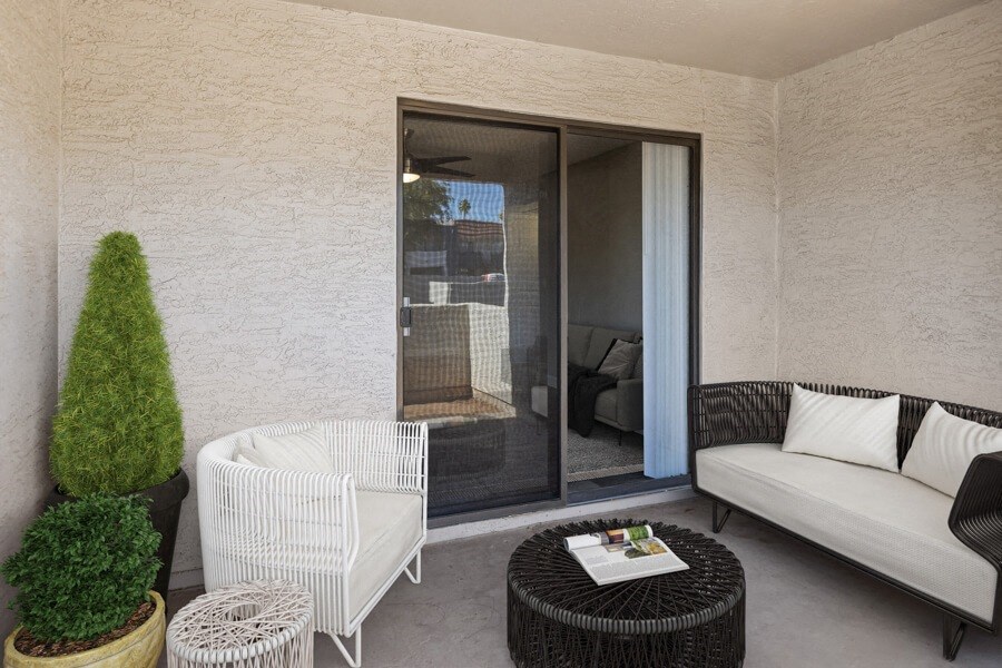 a patio with a white couch and a black coffee table